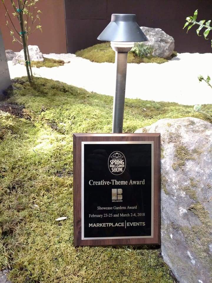Close detail of a Creative-Theme Award plaque beside a landscape lighting fixture