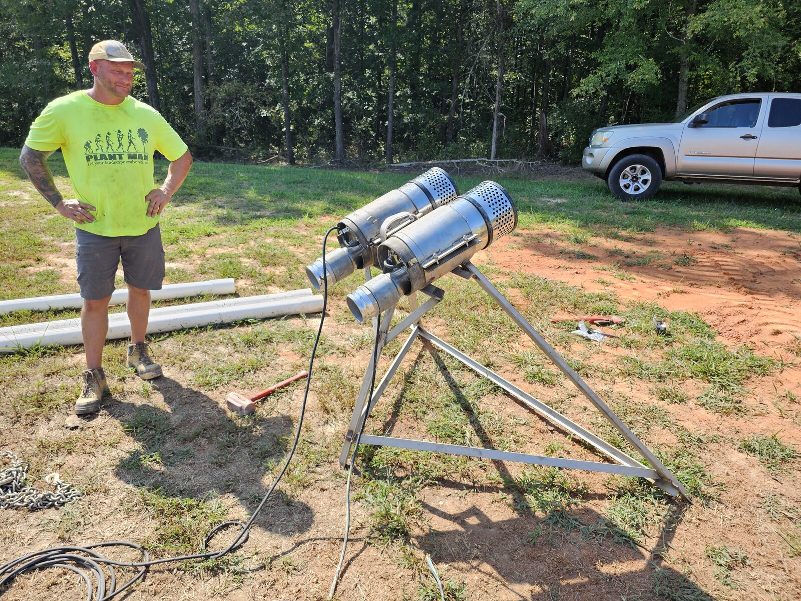 The custom-fabricated stainless steel tripod support built to suspend the water feature's circulation pumps, staged before installation